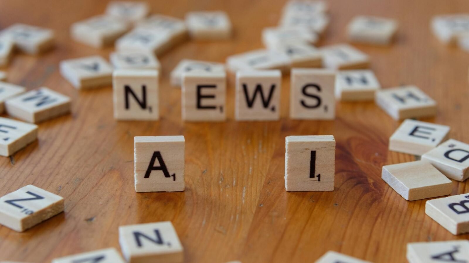 Hölzerne Scrabble-Steine mit den Buchstaben „AI“ und „NEWS“ für ein Bild mit einem technischen Konzept.