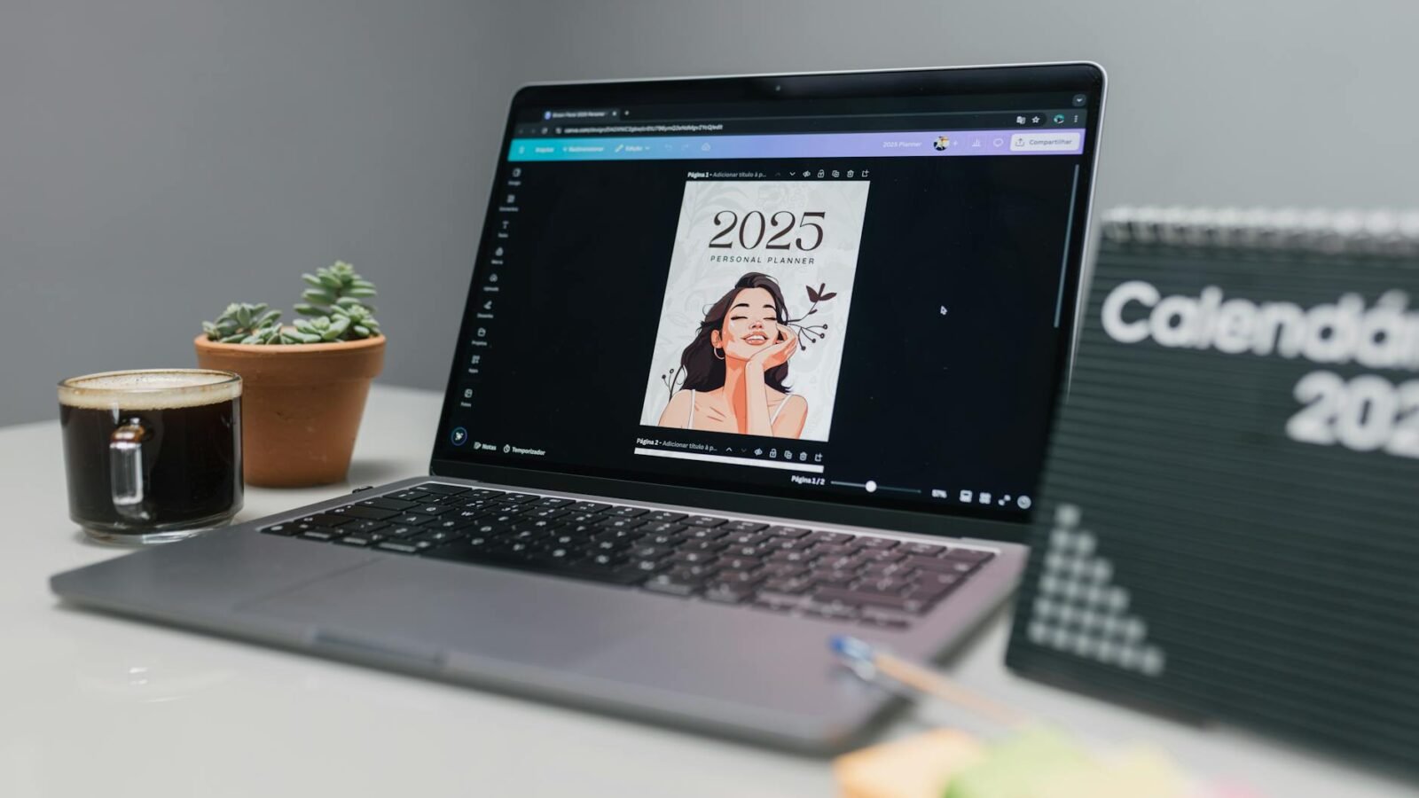 Gemütlicher Arbeitsplatz mit Laptop, Planer für 2025, Sukkulente, Kaffee und Kalender.